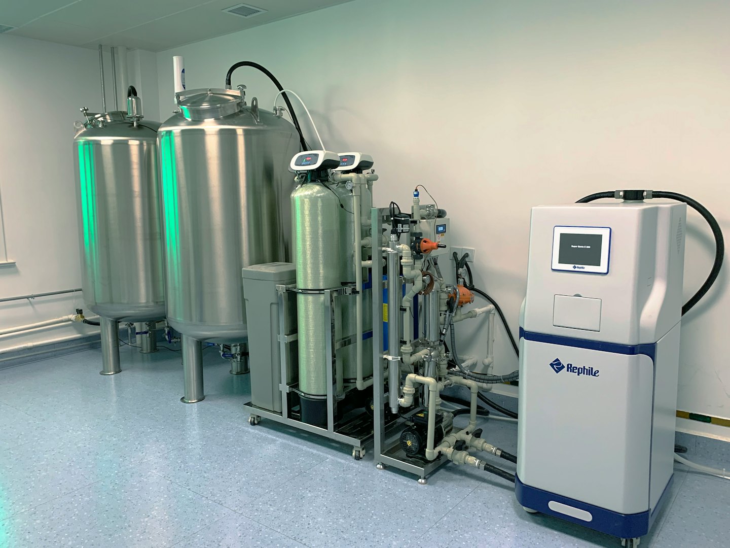 Sistema industrial de purificación de agua con tanques de acero inoxidable y unidades de filtración.